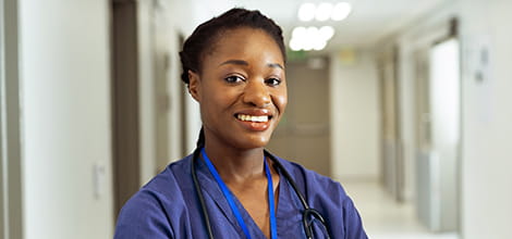 Smiling doctor in hospital corridor facing the camera